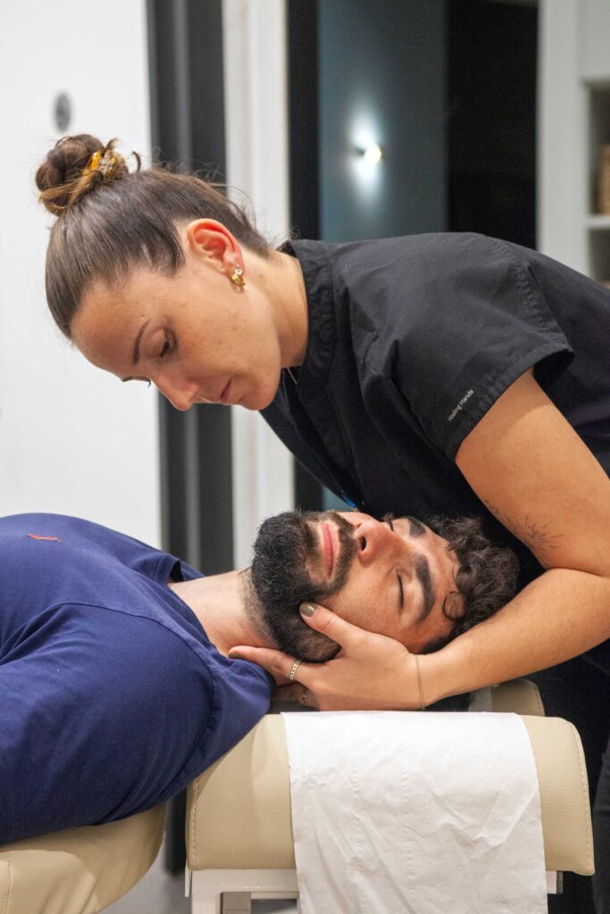 Quiropráctica realizando un ajuste cervical a un cliente en Almería Quiropráctica