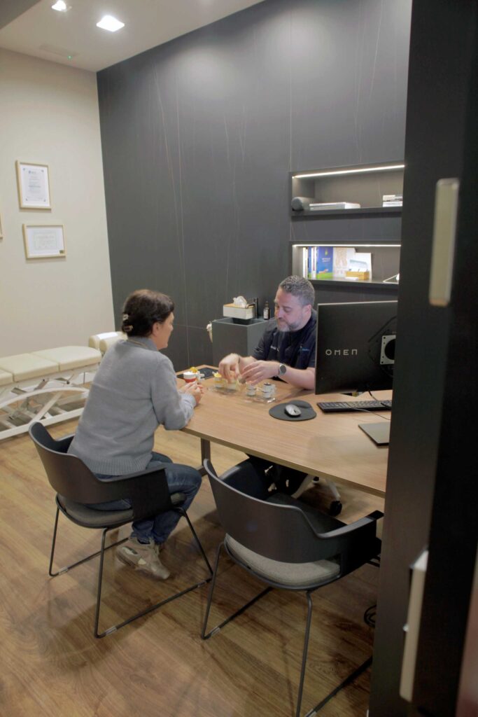Quiropráctico atendiendo a una cliente durante una consulta en Almería Quiropráctica