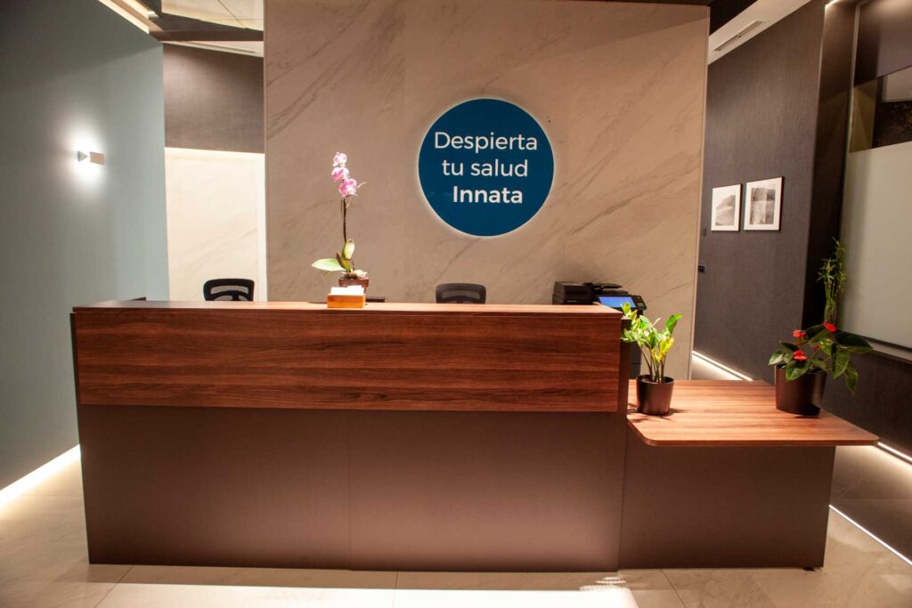 Mostrador de recepción de Almería Quiropráctica con el mensaje Despierta tu salud innata