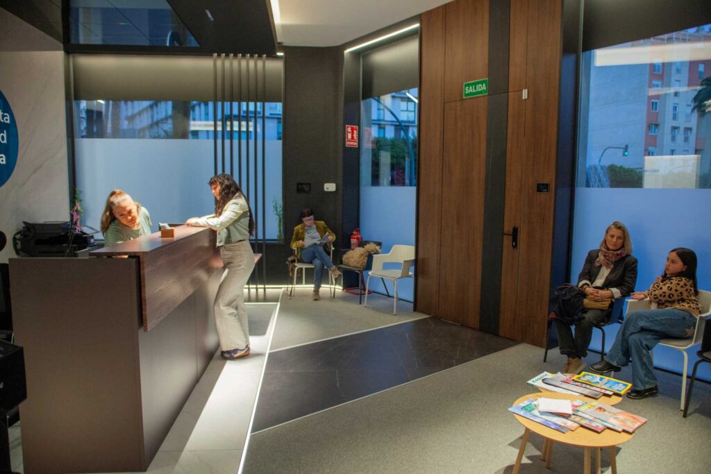 Recepción y sala de espera con clientes en Almería Quiropráctica