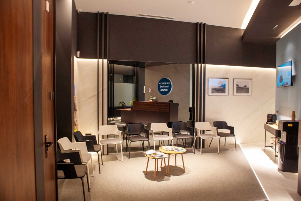 Sala de espera de Almería Quiropráctica con zona de recepción y asientos para clientes