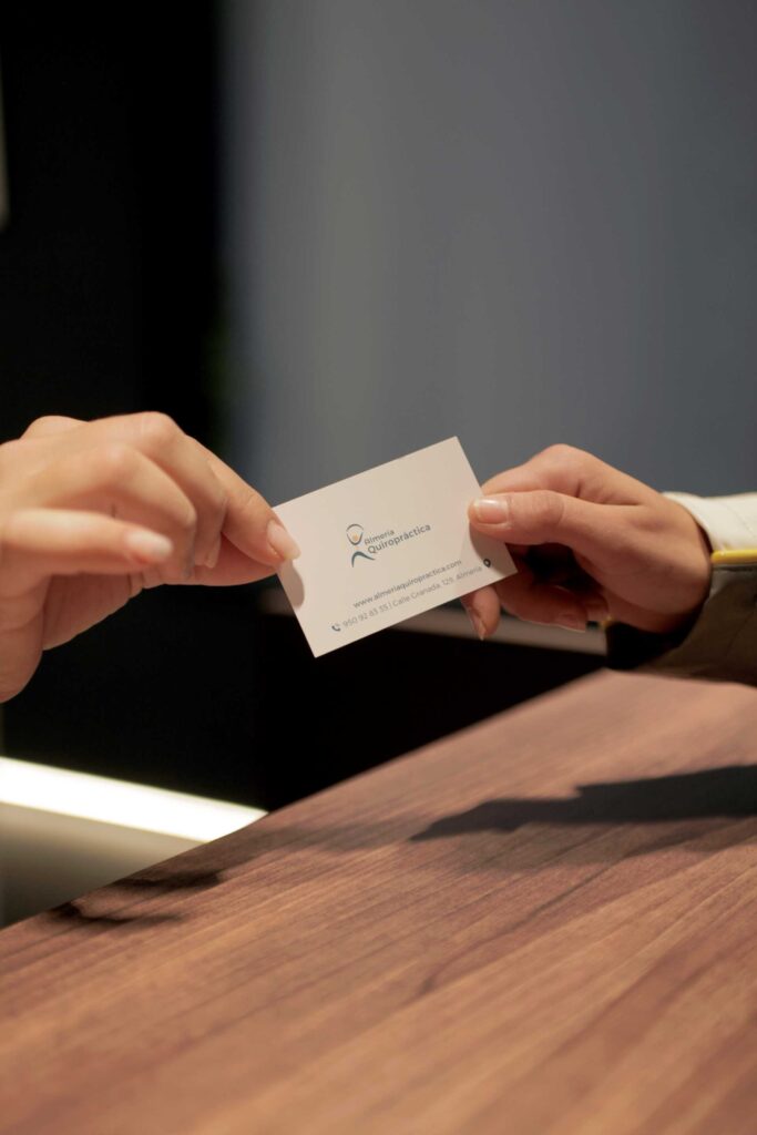 Entrega de tarjeta de contacto de Almería Quiropráctica a una cliente